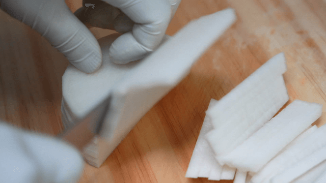 Sharp knife quickly slicing radish on wooden cutting board