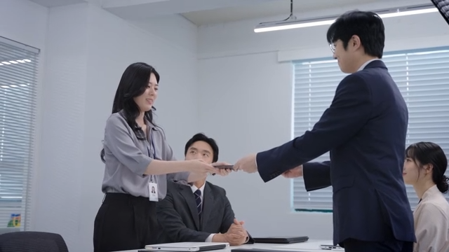 A meeting scene where the signed contract is handed over