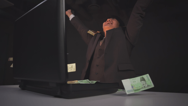 Man celebrating after taking out cash from a briefcase