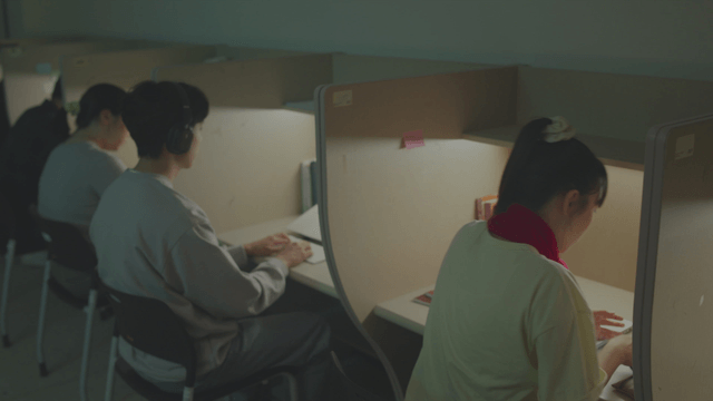 Female student looking at her smartphone in a quiet reading room