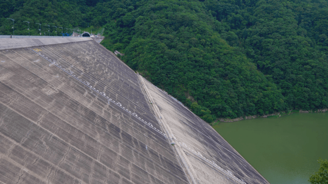 Large lake dam surrounded by green forest