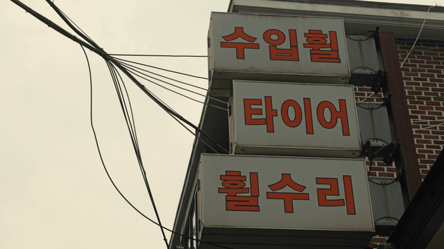 Tire shop sign with wires and brick wall