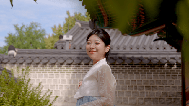 전통 마당에서 미소 짓고 있는 한복 입은 여성