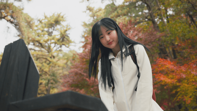 Young woman checking signpost on autumn hiking trail