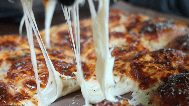 Hand tearing a quattro cheese bagel