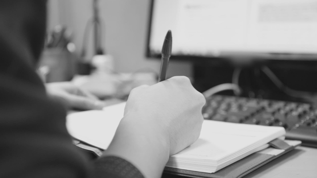 Person writing notes at a desk
