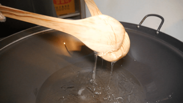 Honey being poured into a large pot