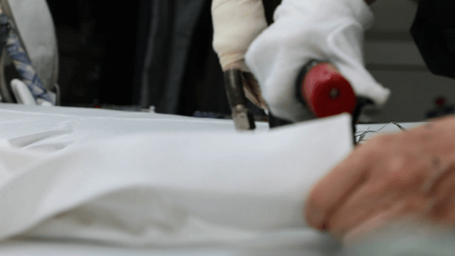 Person ironing clothes in a laundry shop