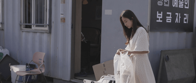 Woman recycling outside a building