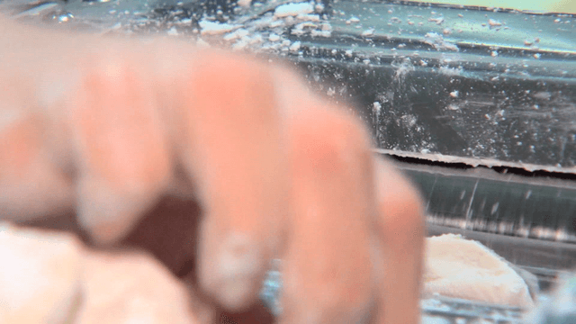 반죽 조각들을 반죽 기계에 빠르게 넣는 손