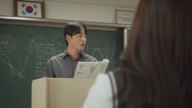 교과서를 보며 설명하는 선생님