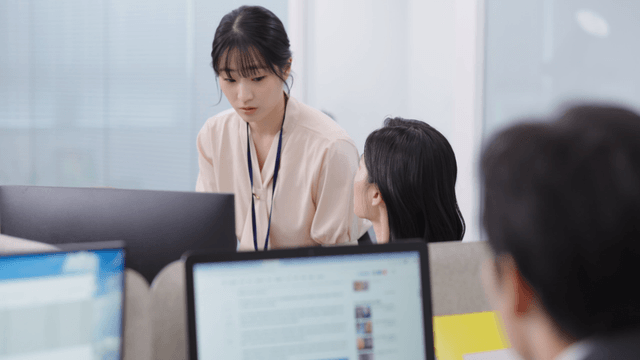Two colleagues discussing work at a desk