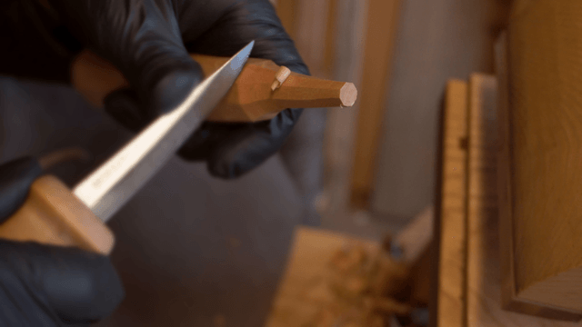 Woodcraft artisan carving wood precisely in workshop