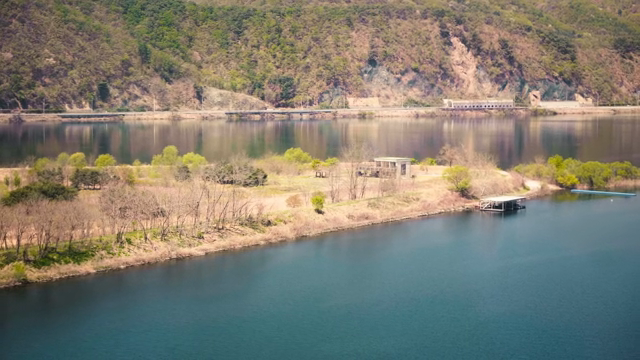 A tranquil lakeside with distant mountains