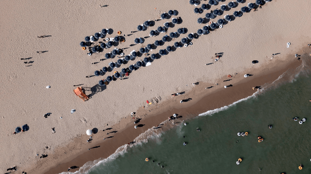 Busy beach with parasols and swimmers