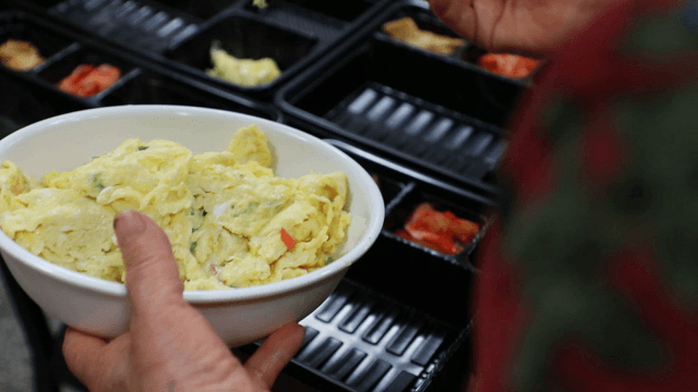 Hand dividing and placing egg dishes into bowls