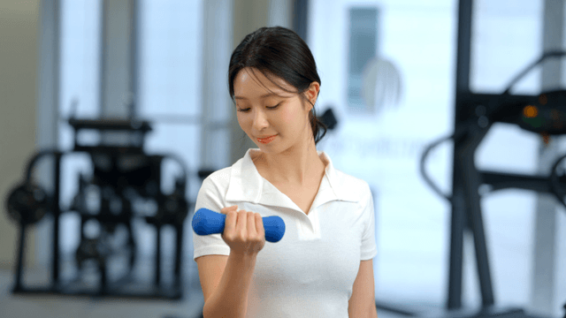 Woman exercising with a dumbbell in a gym