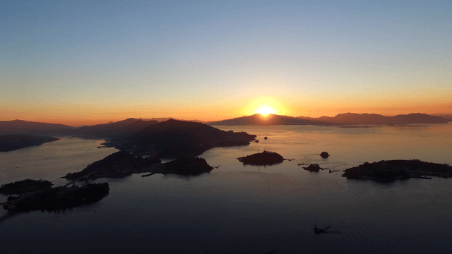 Sunrise over a tranquil sea with islands