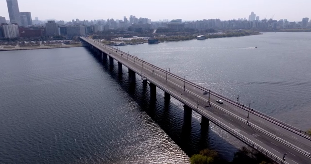 A bridge over a river with city skyline