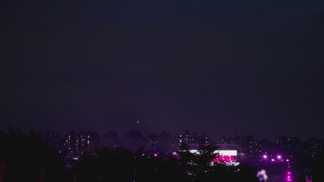 City skyline at night with a vibrant concert view