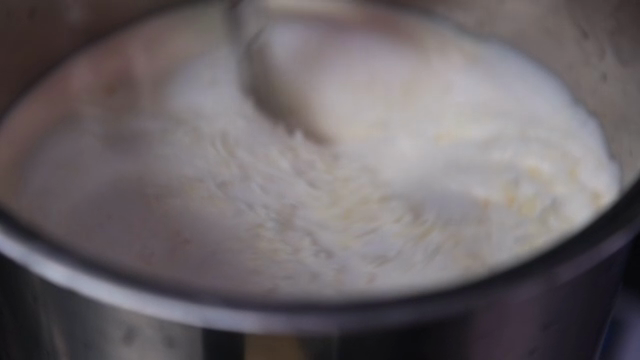 A whisk mixing cheese and soybean soup
