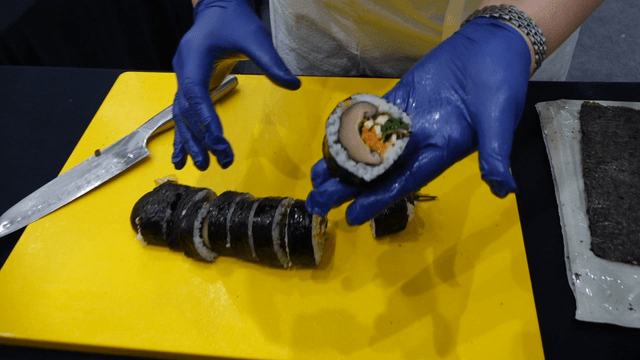 Mushroom gimbap sliced on a cutting board