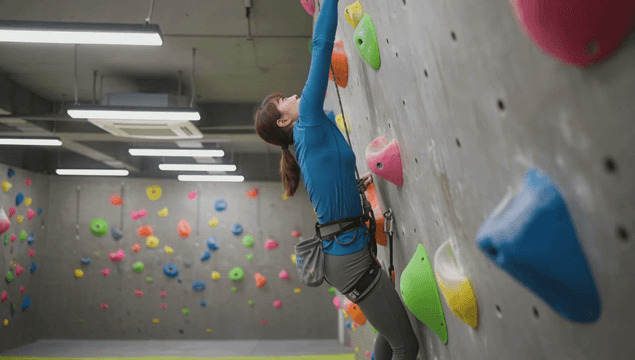 Climbing colorful holds on an indoor wall