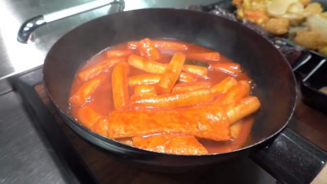 Tteokbokki being served in a pan