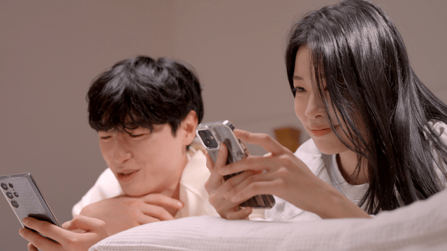 Couple relaxing on bed using their phones