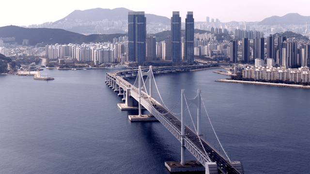 Bridge over the sea leading to a modern city