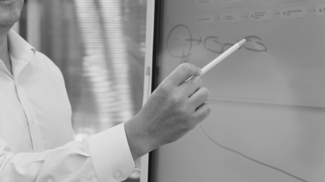 Person pointing at a digital whiteboard
