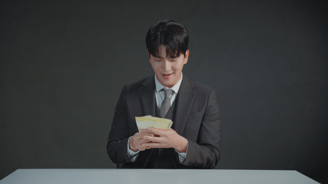 Man in a suit counting money with a satisfied expression