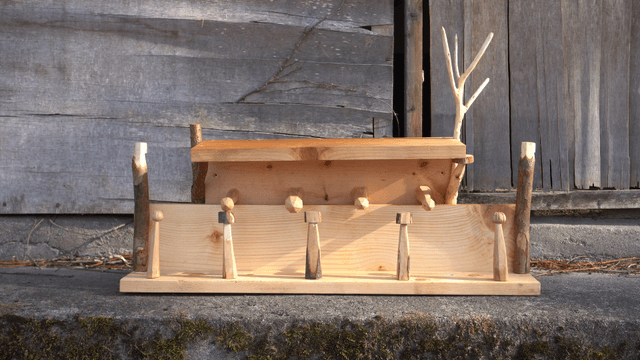 Stacked wooden shelves in front of a rustic wall