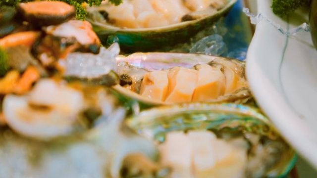 Sliced raw abalone on a shell