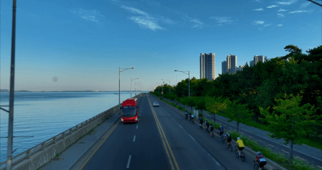 Coastal road with cyclists and skyscrapers