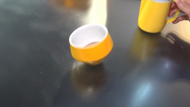 A person swirling an espresso cup