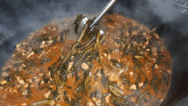 Shovel stirring gatgimchi stew filled with pork