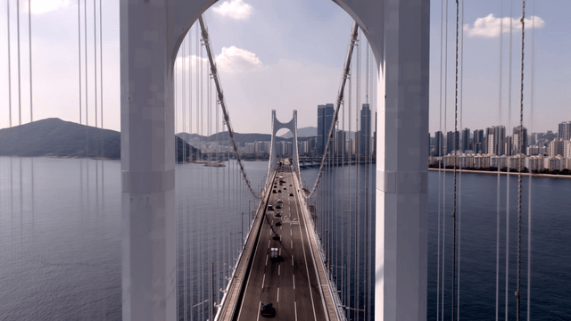 Massive bridge over the sea leading to a modern city skyline