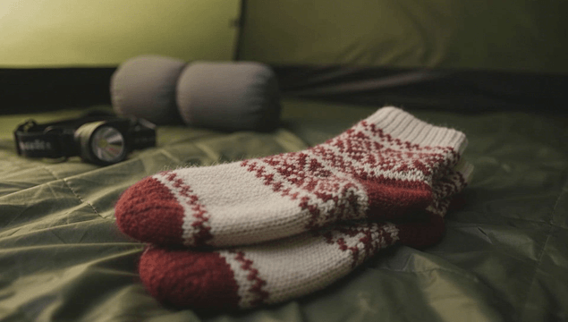Warm socks and camping gear inside windy tent