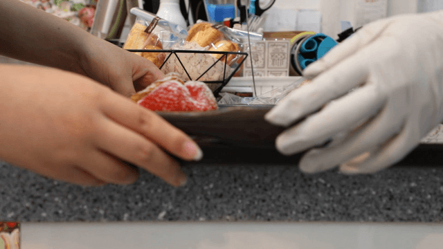Bakery counter with pastries and hands