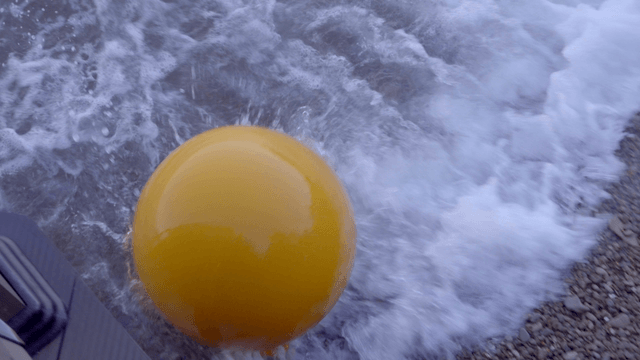 파도와 함께 바위 해변의 노란 부표