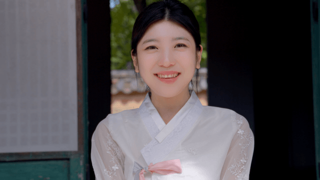 야외에서 미소 짓는 한복을 입은 여성