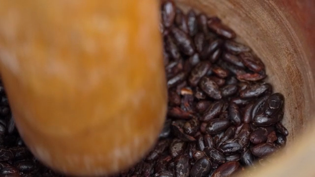 Cacao beans being ground in a mortar