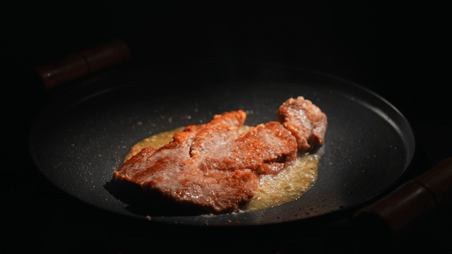 Steak being cooked in a pan