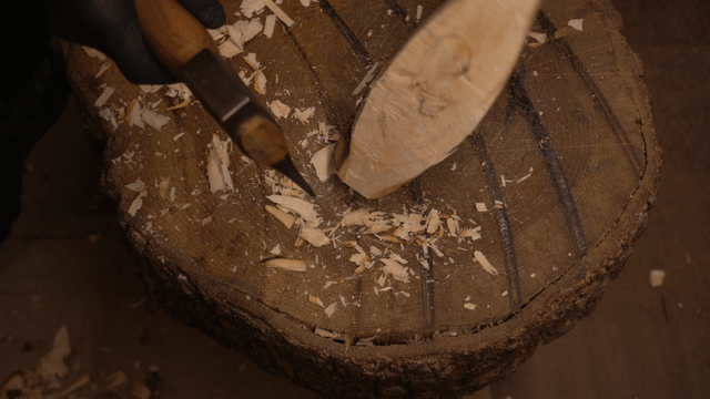 Woodcraft artisan delicately carving tree branches with an axe