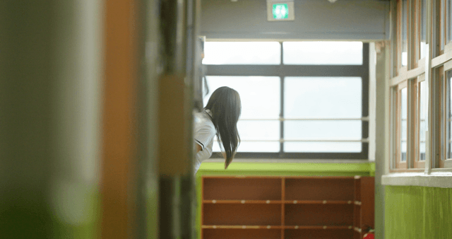 Student peeking in a school hallway