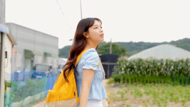 시골길을 걷는 젊은 여성