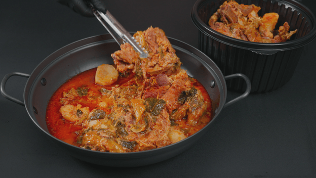 Pork backbone stew being transferred to pot