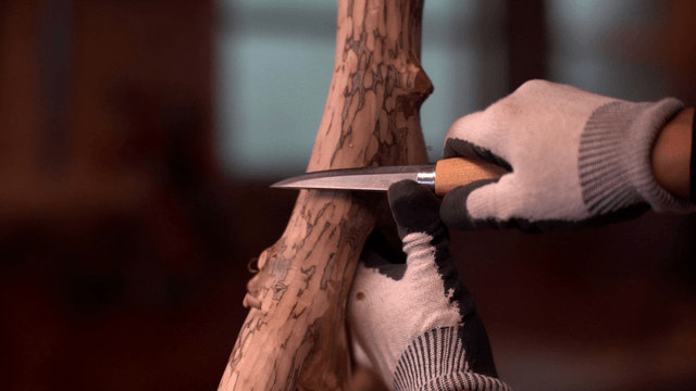 Wood carving with a knife indoors