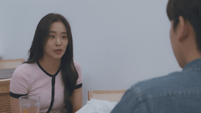 Woman smiling and talking to a man in a cafe